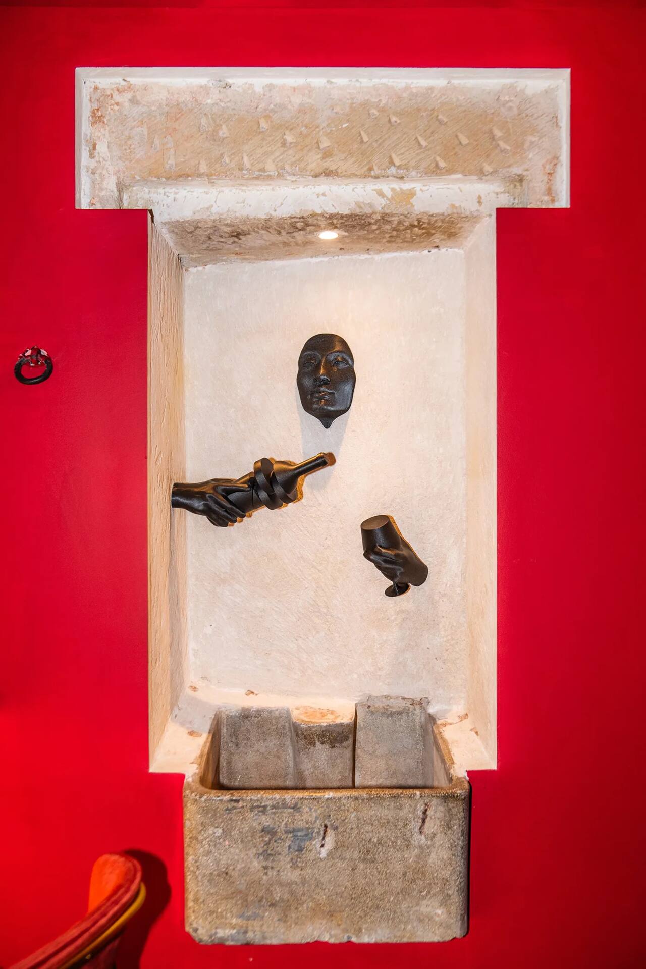 La nicchia in pietra con la scultura che versa il vino